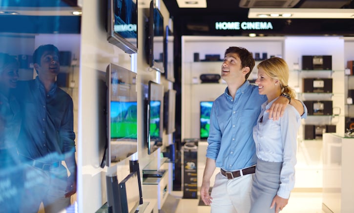 people in consumer electronics  retail store looking at latest laptop, television and photo camera to buy